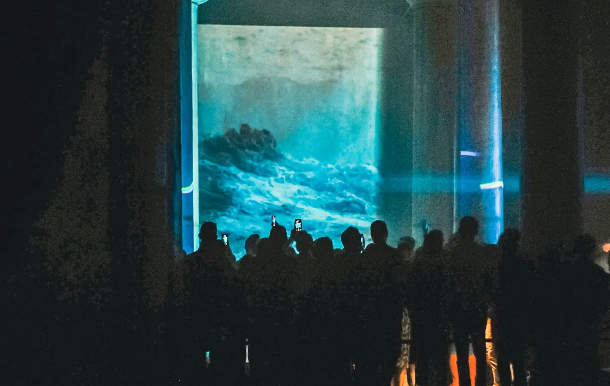 Audience in front of a large screen in a venue